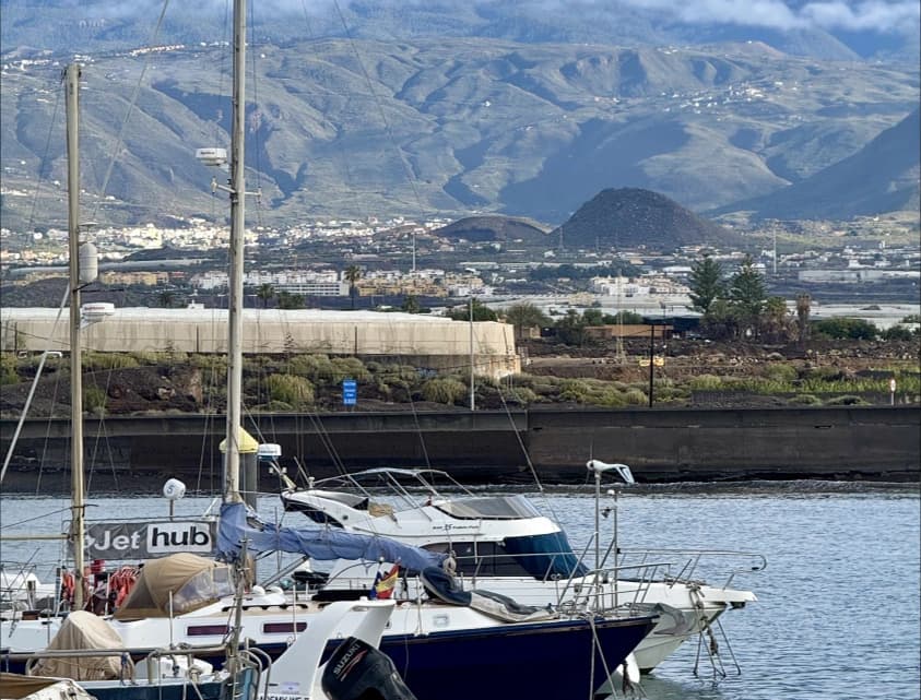 Yachts in a marina beneath a mountain range