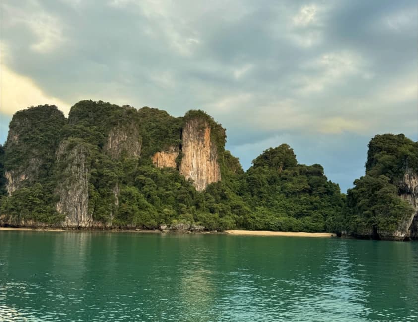 Green limestone cliffs rising above the sea in Thailand